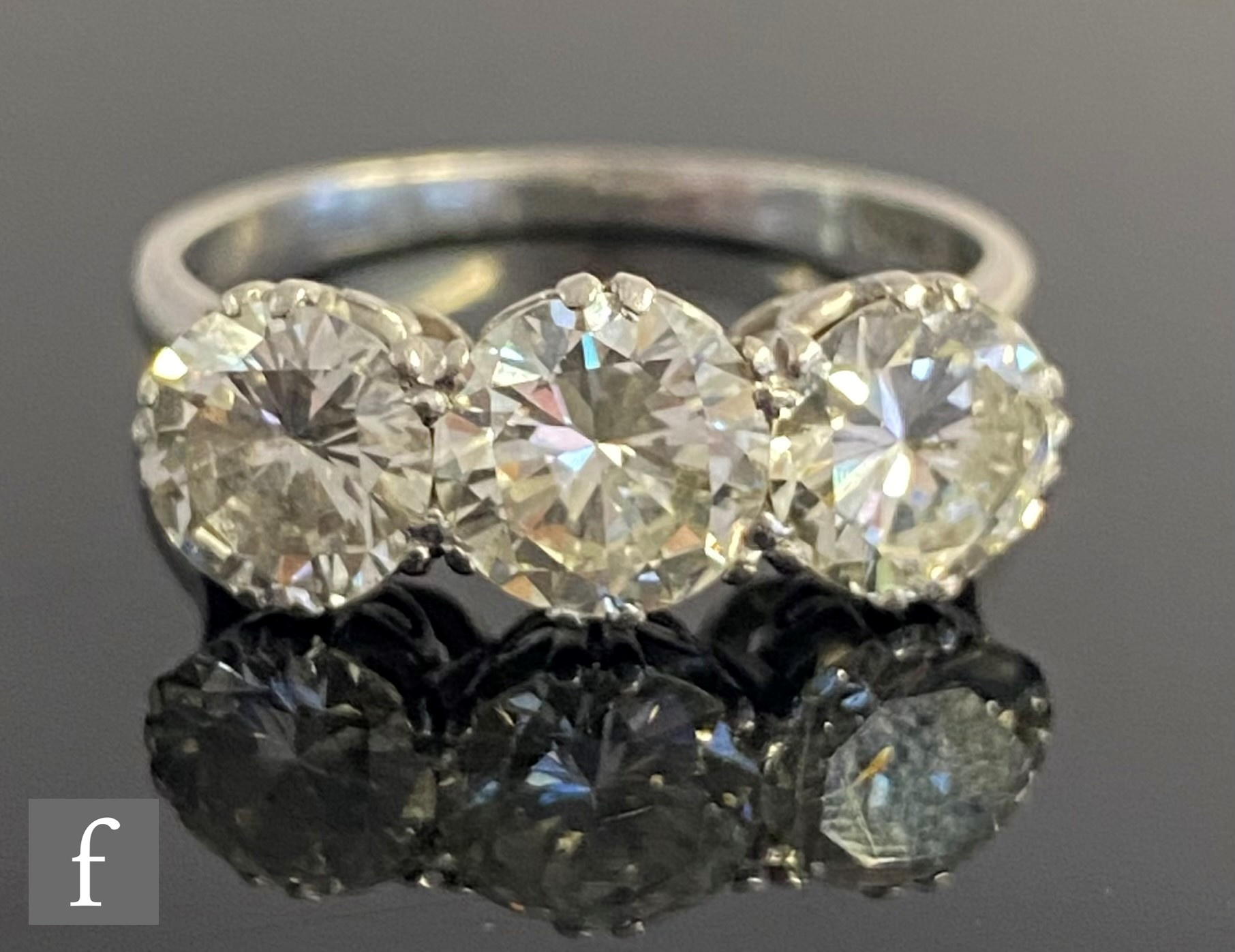 An platinum set diamond three stone ring, brilliant cut claw set stones, total weight - Image 5 of 5