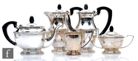 A hallmarked silver five piece pedestal tea set of plain form with reeded details, the three pots