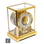 A Jaeger-Lecoultre Atmos clock, circular white dial in brass glazed case, on plinth base, height