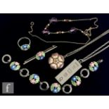 A silver bracelet, brooch and ring each with enamelled floral decorations, all Bernard Instone, with