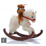 A Steiff 037337 Teddy Bear with Rocking Horse, reddish brown mohair, height 8cm, on white mohair