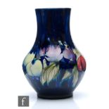 A Moorcroft vase of footed globe and shaft form decorated in the Wisteria pattern, impressed mark