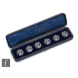 A cased set of six Art Nouveau hallmarked silver circular buttons, each depicting a flower head,