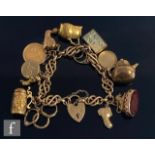 A 9ct fancy link charm bracelet with several charms attached to include a George V half sovereign