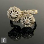 An early 20th Century 18ct double head, cross over diamond cluster ring, each with central diamond