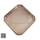 A hallmarked silver Art Deco canted square salver of plain form with raised borders, weight 24oz,