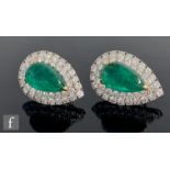 A pair of 18ct white and yellow gold emerald and diamond cluster stud earrings, central claw set