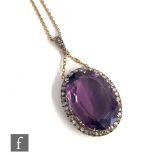 A late 19th Century 9ct amethyst and diamond pendant, central oval facet cut claw set amethyst