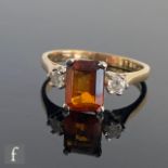A 9ct hallmarked citrine and diamond three stone ring, central emerald cut citrine flanked with a