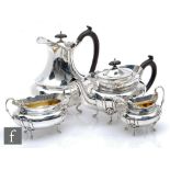 A hallmarked silver four piece, boat shaped tea set each raised on four scroll feet with stylised