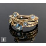 A 9ct hallmarked five stone blue topaz ring, collar set stones to a split shank in the manner of