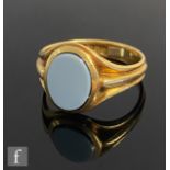 An 18ct hallmarked signet ring set with oval opaque agate to a reeded shanks, weight 7.2g, ring size