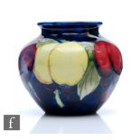 A small Moorcroft vase of ovoid form with a squat roll rim decorated in the Wisteria pattern,