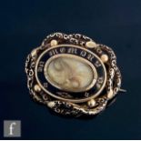 A mid 19th Century 9ct oval memorial brooch with central oval hair panel within gilt In Memory Of