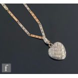 An early 20th Century 9ct diamond set and glass backed heart shaped locket suspended from a twin