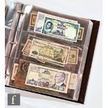 An album containing an extensive collection of world banknotes to include a Britannia five pound and