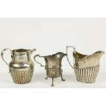 Three English silver Cream Jugs, two with half reeded bodies, and one with paw feet. (3)