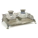 A heavy English pierced silver Desk Stand, on four paw feet, with two silver mounted cutglass ink