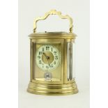 An attractive 19th Century oval cased brass Grande Sonnerie Carriage Clock, the enamel dial with