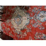 An antique style heavy woollen Carpet, the red ground centre with central floral medallion