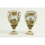 A pair of 19th Century French porcelain two handled Vases, each decorated with figures and houses in