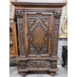 A 17th Century style carved oak Court Cupboard, with moulded cornice above a central door carved