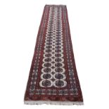 An antique style woollen Carpet Runner, the cream ground centre with double line circular motif with