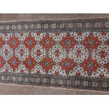 An antique style Middle Eastern Carpet / Runner, the grey ground with multiple red medallions with