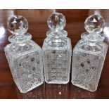 A set of 3 square cutglass Tantalus Decanters, each with prism stopper, 9 1/2" (24cms). (3)