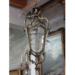 A heavy brass French Hall Lantern, in the rococo style with four glass panels in leaf cast scroll