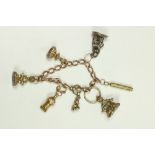 An antique gold oval link Charm Bracelet, with five seals, small Whistle, etc. (a lot)