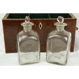 An early 19th Century inlaid mahogany Decanter Box, with four square inscribed glass decanters (ex