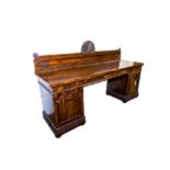 A large William IV period mahogany pedestal Sideboard, the panelled back with a shell crest above
