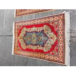 An Oriental style cotton Runner, with a row of medallions on a burgundy ground, 344cms x 81cms (135"