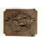 A carved oak Panel, depicting hanging dead game in high relief 15 1/2" x 12" (39cms x 31cms), a