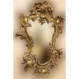 A Louis XVI style shield shaped brass Mirror, of rococo design with floral bouquet and plate mirror.