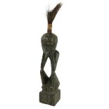 An antique hardwood sculptured Figure, "Yoruba Sage Elder," depicting a seated figure with hands