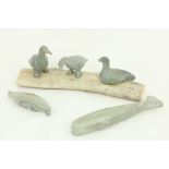 A collection of carved 'Inuit' animal Figures, including a whale, a seal, and three birds mounted on