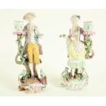 A pair of attractive German porcelain Candlestick Groups, early 20th Century, one modelled as an