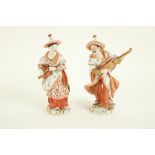 A pair of Sitzendorf porcelain Figures, modelled as an Asian male and female musician, 20cms (