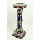 An English pottery Majolica style Jardinière, on a blue ground with foliate decoration, 86cms