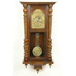 A Vienna beech Wall Clock, with arched brass dial and Arabic numerals and a circular brass