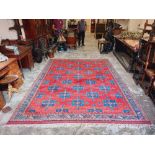 A Dobag Turkish Carpet, the iron red ground with rows of cruciform blue medallions inside a