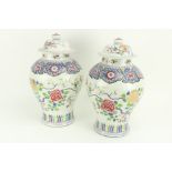 A pair of Chinese baluster shaped Famille Rose porcelain Jars and Covers, decorated with birds and