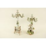 Two similar German porcelain flower encrusted four branch - five light Candelabras, one with cupid