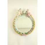 An oval German porcelain flower encrusted Wall Mirror, probably Sitzendorf crested with two