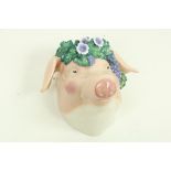 Sonya McGill A ceramic model of a Pigs Head with floral and grape head dress, signed, 33cms high (