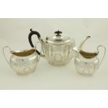 An oval bright cut tapering reeded silver Teapot, Chester 1924, with ebonised handle; together