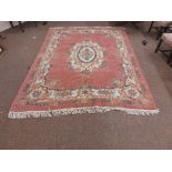 A large pink ground Chinese woollen Carpet, with large central floral bouquet and conforming border,