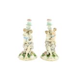 A pair of Dresden porcelain Candlesticks, late 19th Century, each stem with a classical woman and